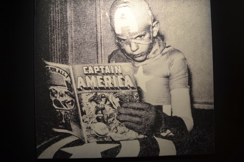 Kid dressed as Captain America reading comics
